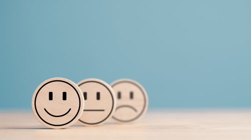 Wooden label with happy normal and sad face icons showing Good Neutral or Negative feedback. Blogpost about Feedback in corporate innovation. 