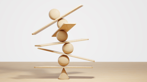 Wooden spheres balancing on seesaw. Concept of harmony and balance. Blogpost about Innovation Risk.